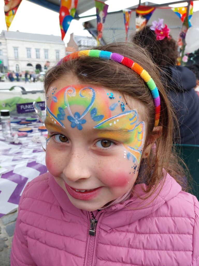 Kindergrime hartjes met glitter op gezicht meisje